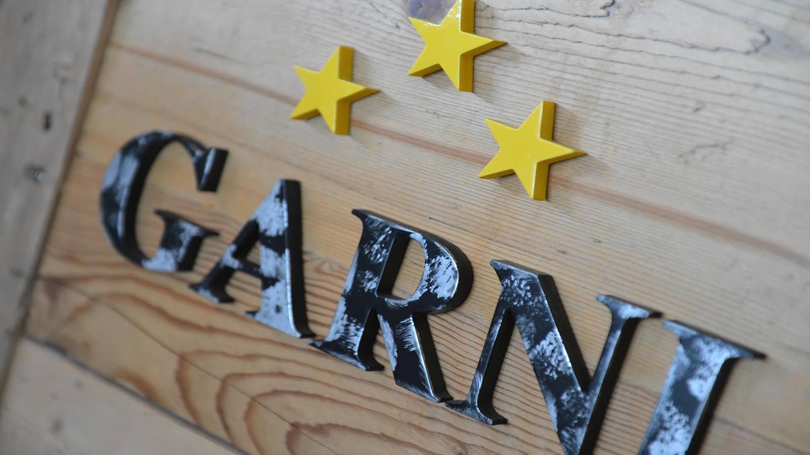 Insegna in legno Garnì con tre stelle dorate