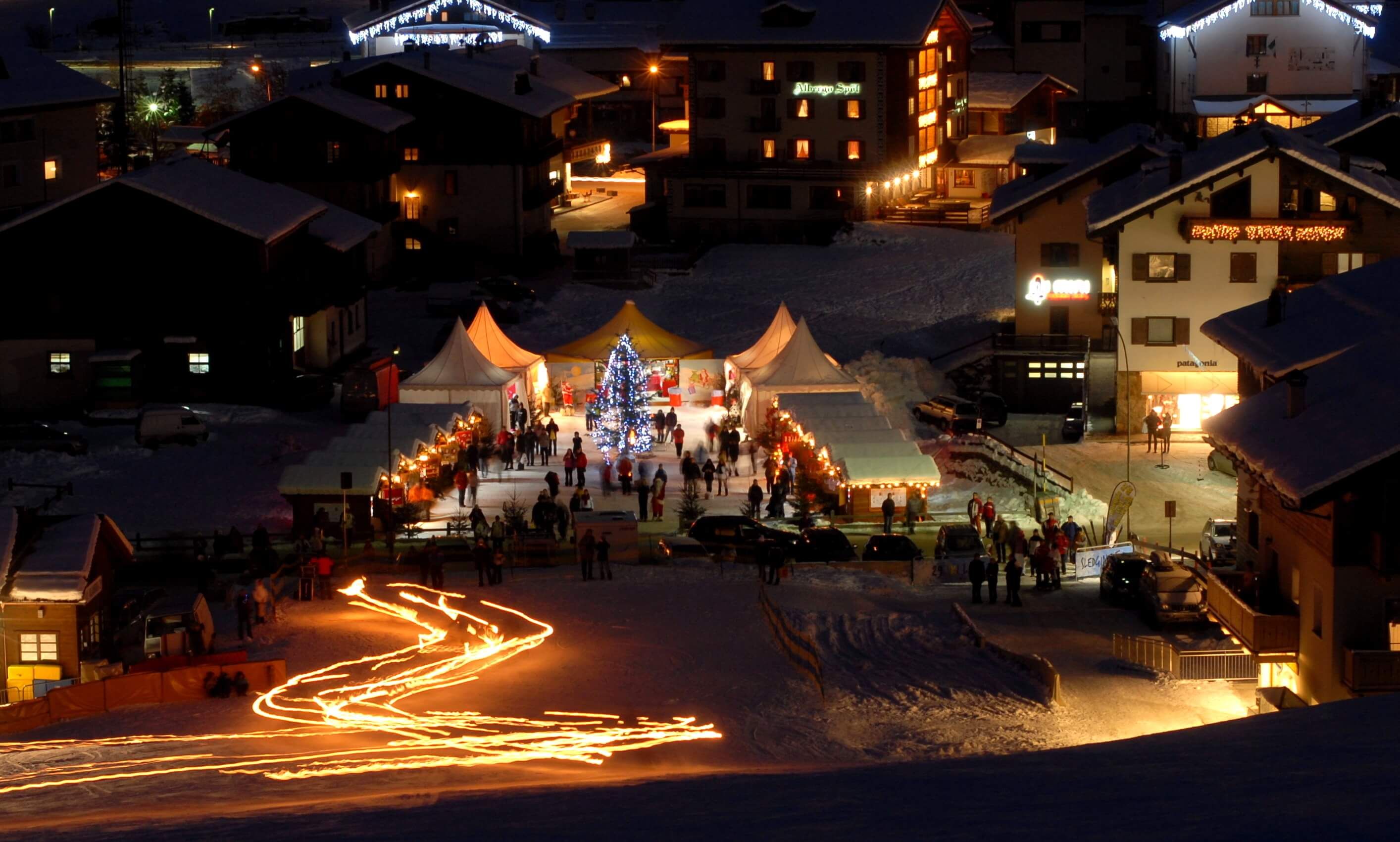 Il paese di Livigno illuminato per il Natale con la fiaccolata sulla neve