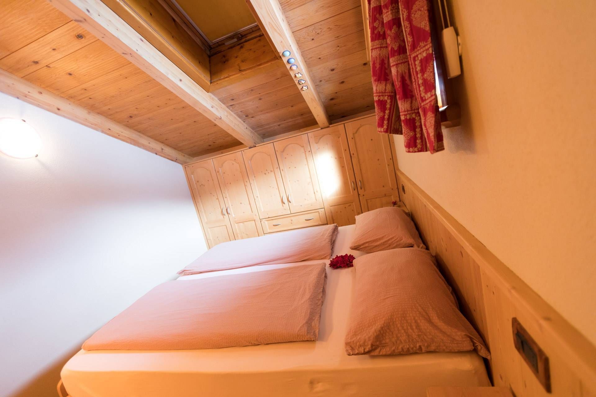 Letto matrimoniale sotto le travi in legno